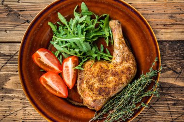 Kümes hayvanları tabağı. Kızarmış tavuk bacağı ve sebze salatası. Karanlık arka plan. Üst görünüm