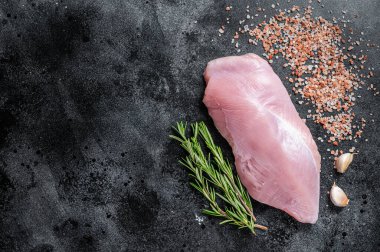 Biberiye ve tuzlu bir kasap masasında çiğ tavuk göğsü fileto eti. Siyah arka plan. Üst Manzara. Boşluğu kopyala