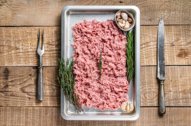 Mutfak tepsisinde hindi ya da çiğ tavuk kıyması. Ahşap arka plan. Üst Görünüm