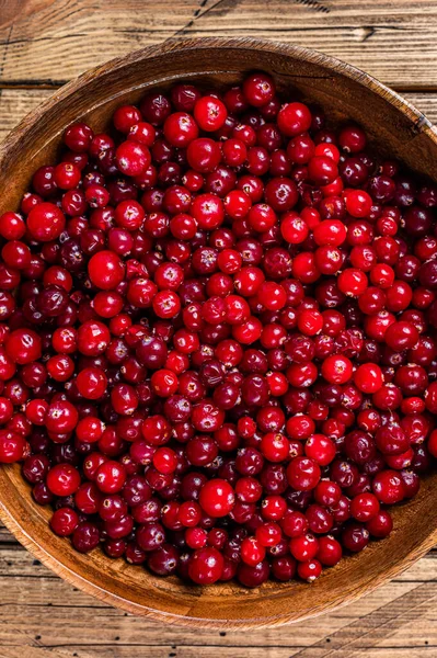 Red Cranberry berry in a wooden plate. Wooden background. Top view — Stock Photo, Image