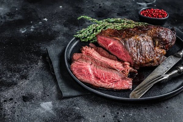 Gegrilde hanger of Onglet rundvlees biefstuk op een bord met tijm. Zwarte achtergrond. Bovenaanzicht. Kopieerruimte — Stockfoto