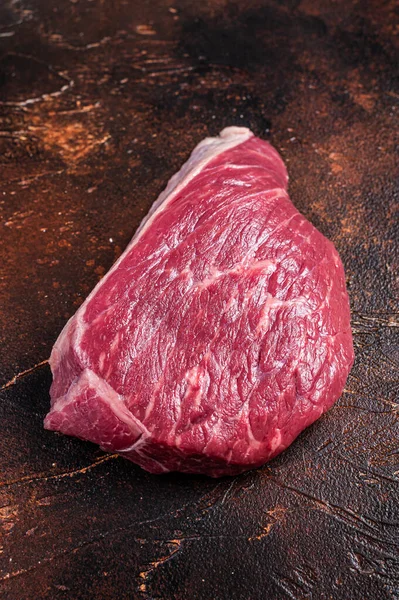 Rauwe rundvlees gesneden of top sirloin vlees biefstuk op de slager tafel. Donkere achtergrond. Bovenaanzicht — Stockfoto