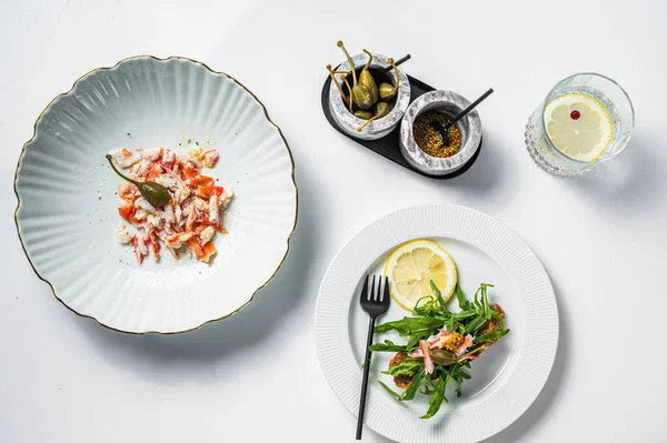 Salade avec viande de crabe sur une table de cuisine. Fond blanc. Vue du dessus — Photo