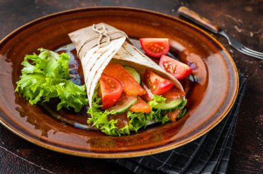 Balık somon ve sebzeli rulo sandviç. Karanlık arka plan. Üst görünüm