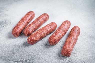 Kasap masasında çiğ et ve kuzu eti kebabı sosis. Beyaz arka plan. Üst görünüm