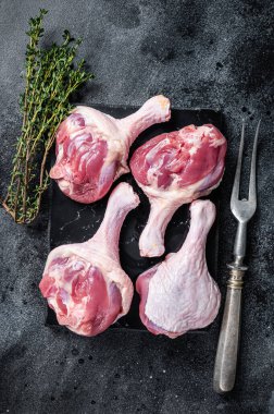 Pişmemiş çiğ ördek butları mermer tahtada. Siyah arka plan. Üst görünüm