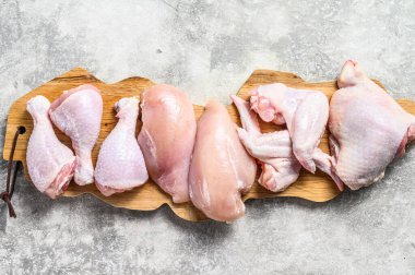 Kesme tahtasında çiğ tavuk eti. Gri arka plan. Üst görünüm