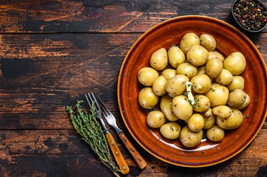 Yeni haşlanmış patates, tereyağı ve doğranmış dereotlu. Karanlık ahşap arka plan. Üst Manzara. Boşluğu kopyala