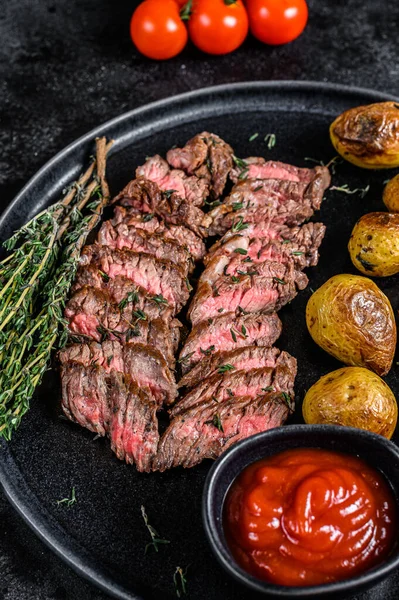 Kızarmış patatesli ızgara mermer biftek. Siyah arka plan. Üst görünüm