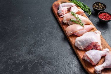 Taze çiğ tavuk eti ve tavuk parçaları. Siyah arka plan. Üst Manzara. Boşluğu kopyala