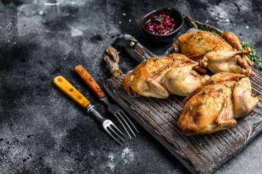 Ahşap kesme tahtasında ızgara bıldırcın. Siyah arka plan. Üst Manzara. Boşluğu kopyala