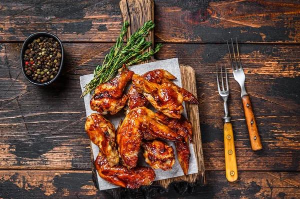 Baked Bbq chicken wings with dip sauce. Dark wooden background. Top view — Stock Photo, Image