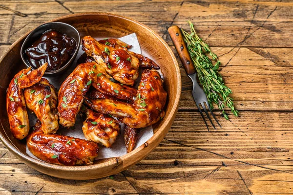 Asas de frango grelhadas com molho de churrasco. fundo de madeira. Vista superior. Espaço de cópia — Fotografia de Stock