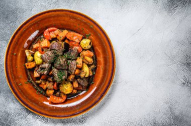 Et güveci, tabakta gulaş. Beyaz arka plan. Üst Manzara. Boşluğu kopyala