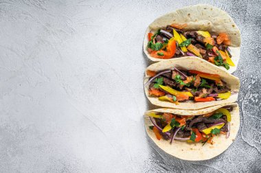 Biftek, soğan ve tatlı biberli Meksika tacoları. Beyaz arka plan. Üst Manzara. Boşluğu kopyala