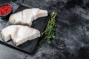 Tahtada çiğ köpekbalığı bifteği. Siyah arka plan. Üst Manzara. Boşluğu kopyala