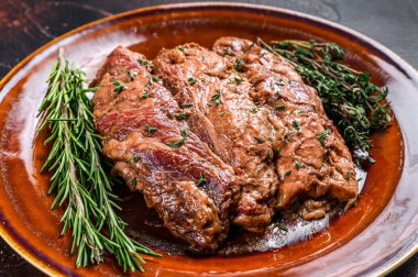 Plata üzerinde terbiye edilmiş bavette bifteği ve bbq sosu. Karanlık arka plan. Üst görünüm