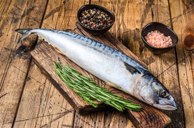 Tahta kesme tahtasının üzerinde kekik ile tuzlu su balığı uskumrusu. Ahşap arka plan. Üst görünüm