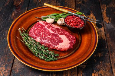 Kırsal bir tabakta siyah angus bifteği. Koyu ahşap arka plan. Üst görünüm