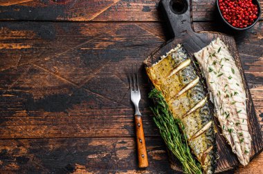 Kavrulmuş uskumru fileto dilimleme tahtasında. Koyu ahşap arka plan. Üst Manzara. Boşluğu kopyala