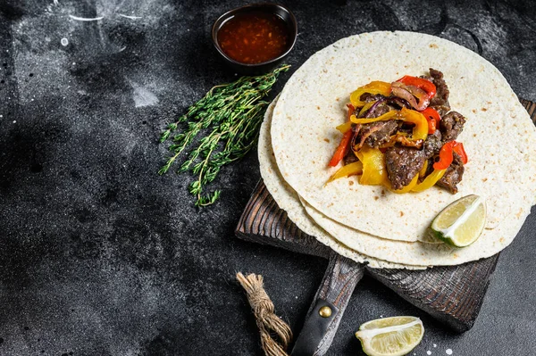 Beef Steak Fajitas with tortilla, mix pepper and onion traditional Mexican food. Black background. Top view. Copy space — Stock Photo, Image