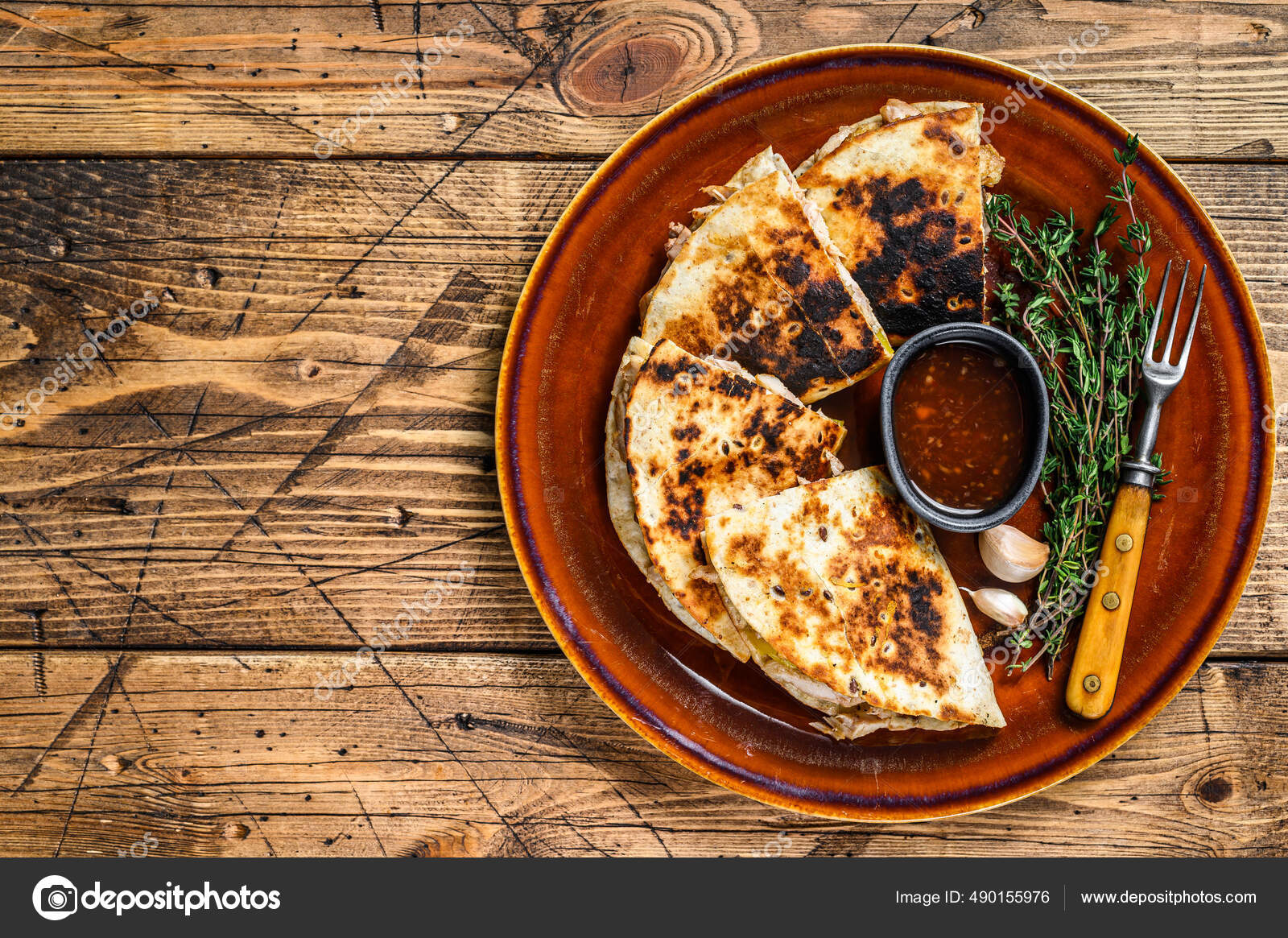 Mexican quesadilla with chicken, paprika, cheese and cilantro on wooden