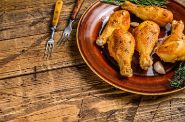 Kırsal bir tabakta taze tütsülenmiş tavuk budu ve otlar. Ahşap arka plan. Üst Manzara. Boşluğu kopyala