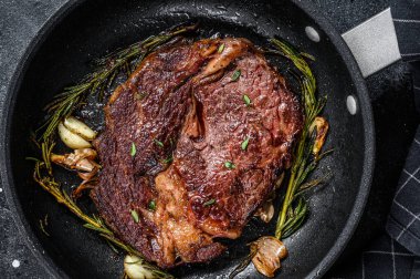 Kavrulmuş biftek, tavada pirzola eti. Siyah arka plan. Üst görünüm