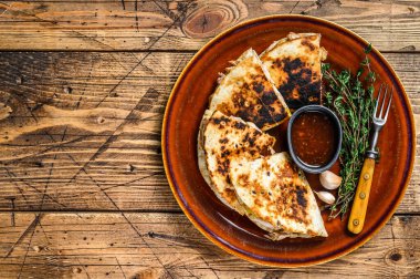 Tavuk, paprika, peynir ve kişniş soslu Meksika quesadilla 'sı. Koyu ahşap arka plan. Üst görünüm