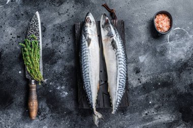 Tahta kesme tahtasındaki çiğ balık uskumrusu. Siyah arka plan. Üst görünüm