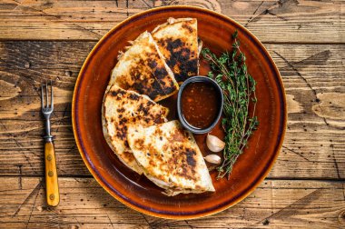 Tavuk, paprika, peynir ve kişniş soslu Meksika quesadilla 'sı. Koyu ahşap arka plan. Üst görünüm