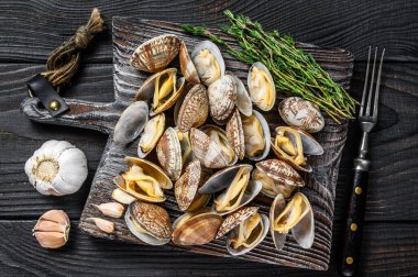 Tahta kesme tahtasında midye kabuğu. Siyah ahşap arka plan. Üst görünüm