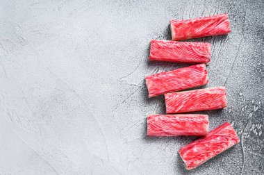 Yengeç surimi mutfak masasına yapışıyor. Beyaz arka plan. Üst Manzara. Boşluğu kopyala