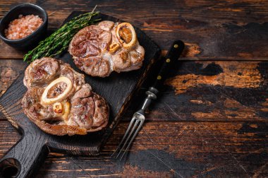 Osso Buco bifteği, İtalyan ossobuco bifteği. Koyu ahşap arka plan. Üst Manzara. Boşluğu kopyala
