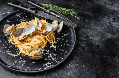 Deniz mahsullü spagetti makarna ile midye yahnisi tabakta. Siyah arka plan. Üst Manzara. Boşluğu kopyala