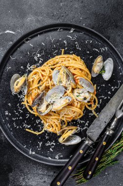 Deniz mahsullü spagetti makarna ile midye yahnisi tabakta. Siyah arka plan. Üst görünüm