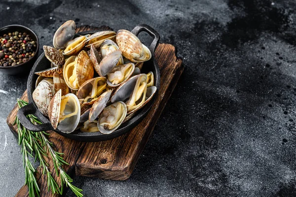 Amêijoas cozidas vongole em uma panela. Fundo preto. Vista superior. Espaço de cópia — Fotografia de Stock