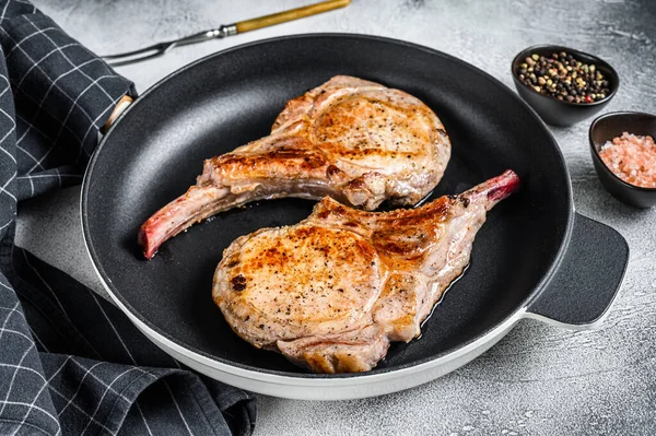 Geroosterde varkensvlees biefstuk in een pan. Witte achtergrond. Bovenaanzicht — Stockfoto