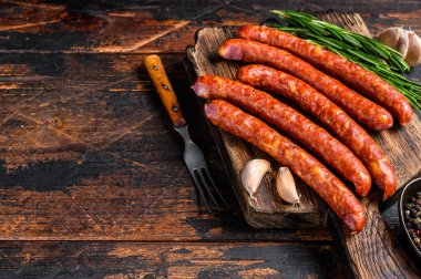 Taze aromatik otlar ve baharatlarla birlikte sıcak füme sosis. Koyu ahşap arka plan. Üst Manzara. Boşluğu kopyala