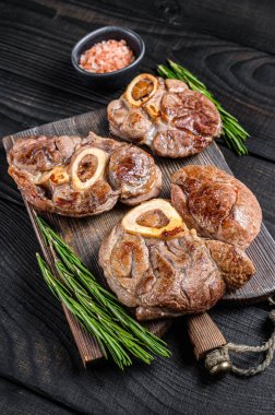 Osso buco dana incik bifteği, italyan ossobuco pişirdi. Siyah ahşap arka plan. Üst görünüm