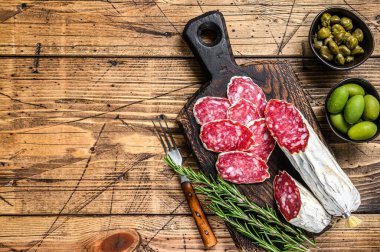 Tahta kesme tahtasının üzerinde ince dilimlenmiş salam salçamı. Ahşap arka plan. Üst Manzara. Boşluğu kopyala