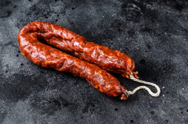 İspanyol sucuklu sosis. Siyah arka plan. Üst görünüm