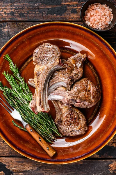 Côtelettes de viande de mouton d'agneau grillé barbecue steaks sur une assiette. Fond en bois foncé. Vue du dessus — Photo