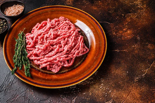 Rå malning angus wagyu nötkött, malet kött med örter på en tallrik. Mörk bakgrund. Högst upp. Kopiera utrymme — Stockfoto