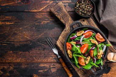 Karışık yapraklı sağlıklı bistro yeşil salata. Mangold, İsviçre pazısı, ıspanak, roka ve fındık. Koyu ahşap arka plan. Üst Manzara. Boşluğu kopyala