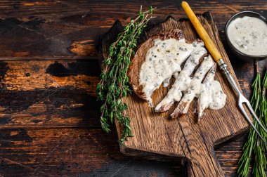 Biftek bifteği ve ahşap tahtada biber sosu. Koyu ahşap arka plan. Üst Manzara. Boşluğu kopyala