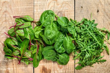Salata yaprakları, Arugula, ıspanak ve Swiis Chard karışımı. Ahşap arka plan. Üst görünüm