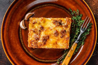 İtalyan lazanyası, domates sosu ve kıymalı kıyma. Karanlık arka plan. Üst görünüm