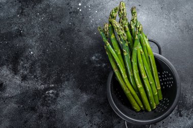 Eski bir kevgire çiğ yeşil kuşkonmaz. Siyah arka plan. Üst Manzara. Boşluğu kopyala