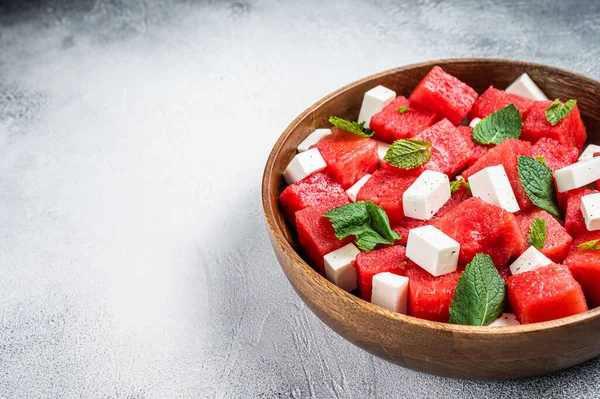 Watermeloen Salade met feta kaas in een houten bord. Witte achtergrond. Bovenaanzicht. Kopieerruimte — Stockfoto